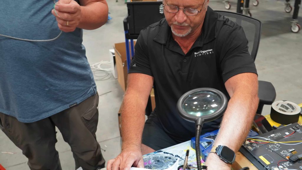 Elation CEO Christian Rogne soldering electronics for the CELSIUS Football Toss